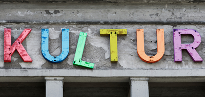 Schriftzug KULTUR bestehend aus verschieden-farbigen Buchstaben, die auf einer Hausfassade angebracht sind