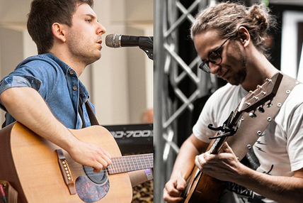 Foto: Zwei Männer, die Gitarre spielen, vor dem einen steht ein Mikrofon in das er spricht oder singt