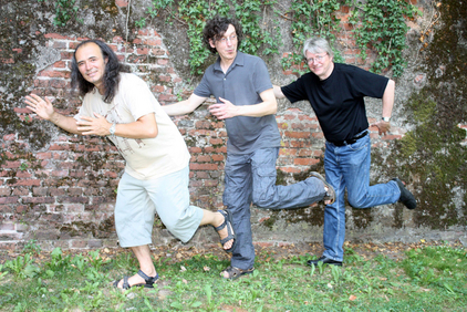 Die Mitglieder von Mannijo stehen auf einer Wiese vor einer Steinmauer 