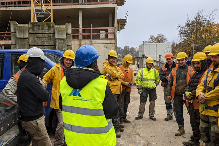 Arbeiter mit Warnwesten und Schutzhelm auf einer Baustelle