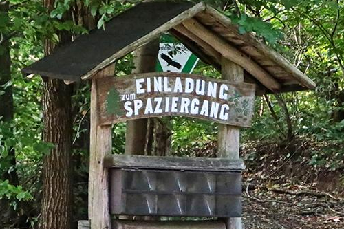 Holzhinweiser mit der Aufschrift "Einladung zum Waldspaziergang" Foto: Ronald Westheide