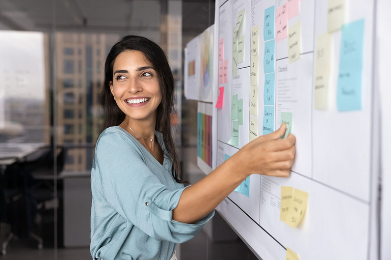 Junge Frau plant am Pinboard