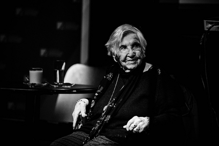 Foto, schwarz-weiß: Esther Bejerano sitzt an einem Tisch und lächelt